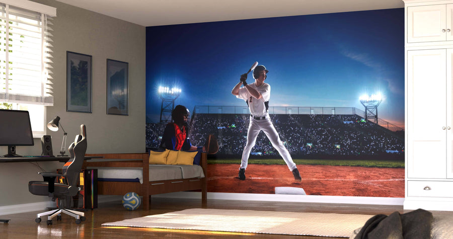 A bedroom with a bed, desk, and white cabinets features the “At the Plate Wall Mural,” showing a baseball stadium at night with a batter under bright lights and a crowd in the background.