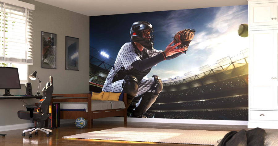 A bedroom showcases the Baseball Catch Wall Mural, depicting a catcher in uniform poised in a stadium. Sunlight brightens the modern decor, which includes a desk, daybed, and a soccer ball on the floor.