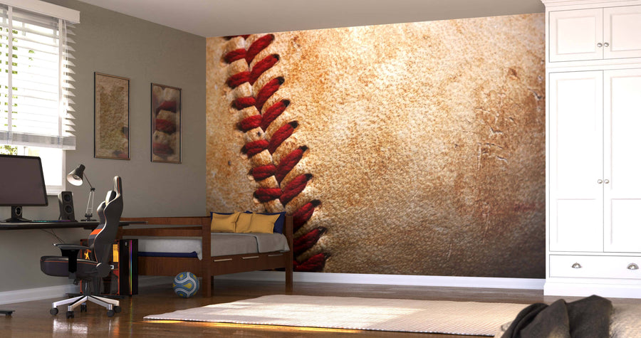 A modern bedroom features the Baseball Macro Close Up Wall Mural with vivid red stitching. The space includes a bed, computer desk, chair, framed pictures, soccer ball under the bed, large white wardrobe, and sunlight through window blinds.