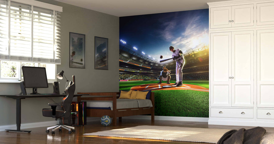 A bedroom with a desk, computer, and bed features the Baseball Players on Grand Field Wall Mural showing a dramatic baseball scene under stadium lights. Sunlight streams in, and a soccer ball rests on the floor near the bed.
