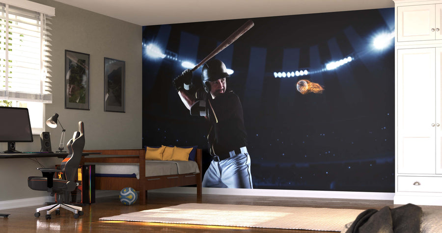 A bedroom with a desk, chair, and bed features the Blazing Fastball Wall Mural of a baseball player under stadium lights, along with framed pictures, a soccer ball, and window blinds for a personalized touch.