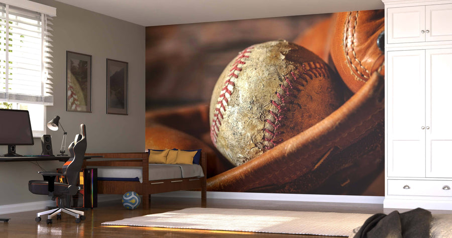 A bedroom with a desk, chair, single bed, and white wardrobe is highlighted by the Classic Leather and Stitch Wall Mural. Framed pictures and sports decor, like a blue and white soccer ball, add the finishing touches.