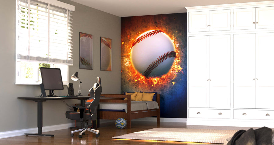 A modern bedroom features the Fiery Fastball Wall Mural as a focal point, with a bed, white cabinets, desk with computer and gaming chair, framed sports art, striped pillow, and soccer ball on the floor illuminated by sunlight through blinds.