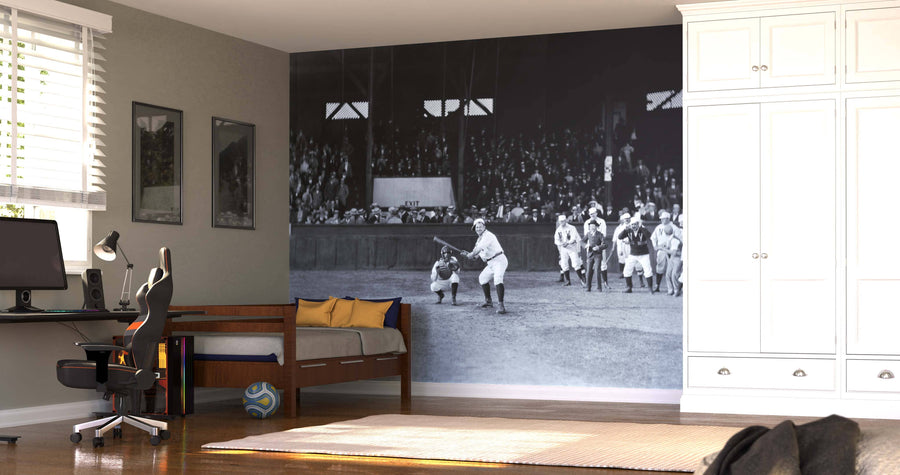 A bedroom with a desk, computer, and bed features the Game On The Line Wall Mural—a large black-and-white print of an old-time baseball game. Modern furnishings, light wood flooring, and removable wallpaper make for easy style updates.