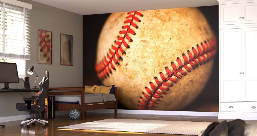 A bedroom features a desk, chair, and computer on the left, a daybed with a blue striped pillow, and a Used Baseball Wall Mural. Sunlight streams through white blinds while a soccer ball rests on the floor.