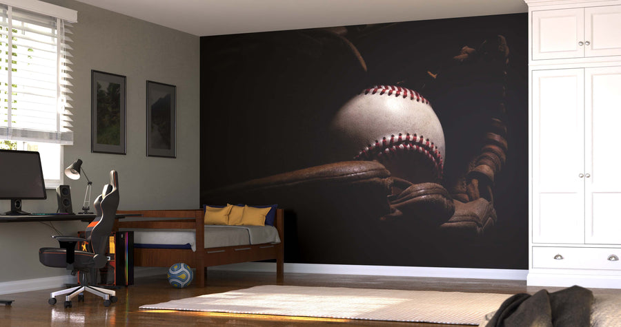 A modern bedroom with a desk, chair, and single bed showcases the Used Baseball and Glove Wall Mural. Light from window blinds brightens the space, which also features a white closet, framed wall art, and a ball on the floor.