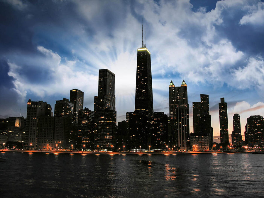 A modern conference room with a long wooden table, black chairs, and glass walls features the Chicago Skyline at Sunset Wall Mural. Natural light from large windows on the left highlights this dramatic mural on the far wall.