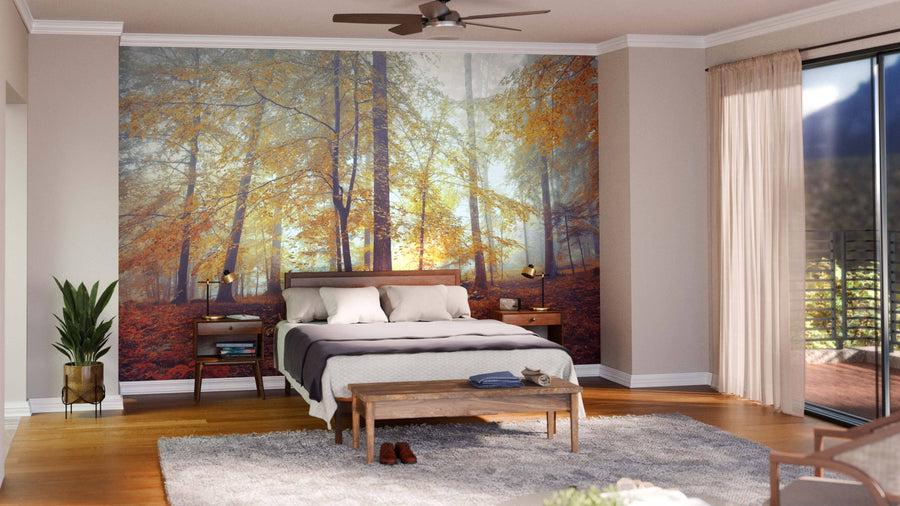 A cozy bedroom with a large bed, bedside tables, lamps, and a wooden bench. The focal wall displays the Colorful Autumn Leaves Wall Mural. There’s a plant, soft rug, ceiling fan, and glass doors with sheer curtains.