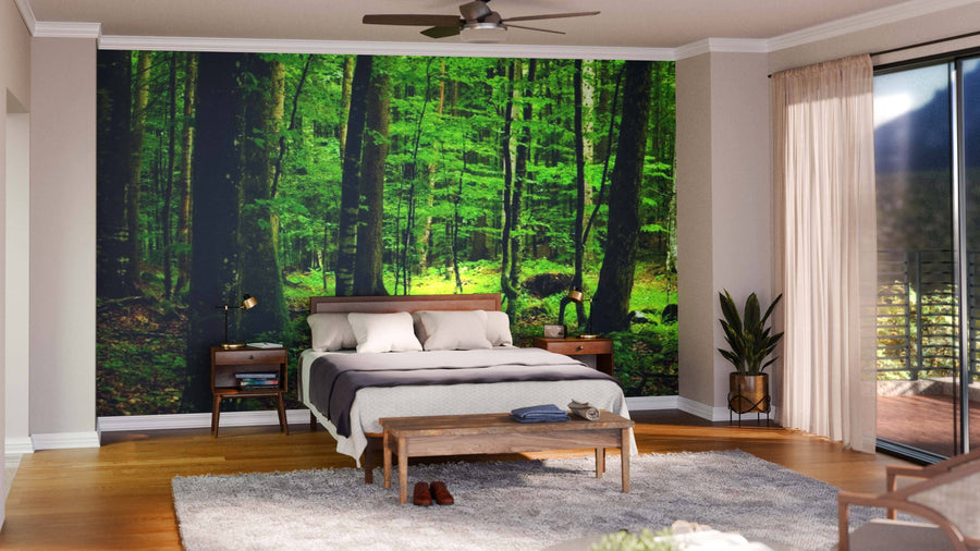 A modern open-plan living and dining room features wooden floors, dark chairs, a large rug, indoor plants, pendant lights, and the Deep Green Forest Panorama Wall Mural for a nature-inspired and cozy atmosphere.