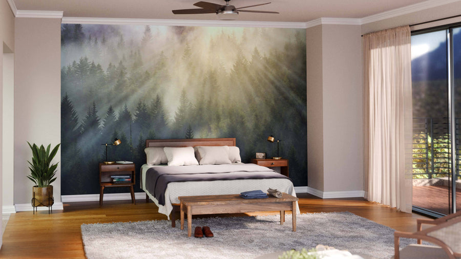 Modern open living-dining area with wood floors, green armchairs, gray sofa, and unique bench. The Foggy Forest with Sun Rays Wall Mural defines the space. Dining table, globe pendant lights, and kitchen are seen in the background.