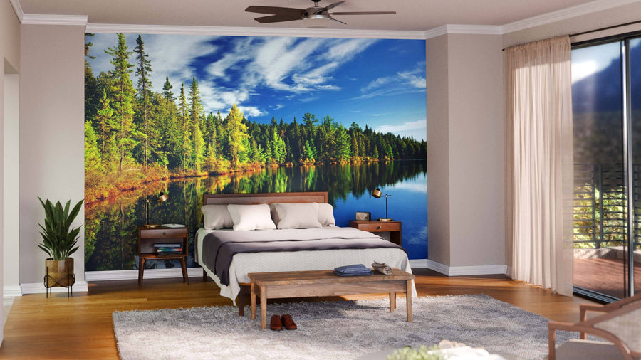 A stylish, cozy living-dining area with wooden floors, mid-century furniture, pendant lights, a rug, an open kitchen, and a Forest Reflecting in Lake Wall Mural as a scenic focal point.