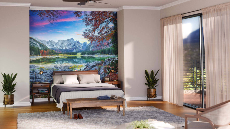 A modern open living-dining area with wood floors, blue armchairs, and a wooden dining table features the Fusine Lake with Mangart Peak Wall Mural. The kitchen has white cabinets, yellow accents, and pendant lights above the table.