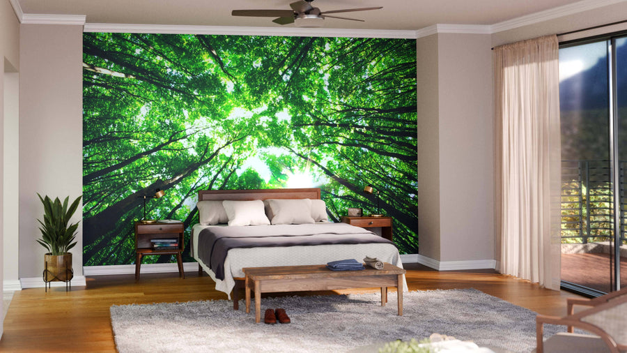 Modern open-plan living/dining area with wood floors and mid-century furniture, featuring the Green Forest Through the Canopy Wall Mural as a stunning focal point. Globe pendant lights illuminate a cozy seating area and dining table.