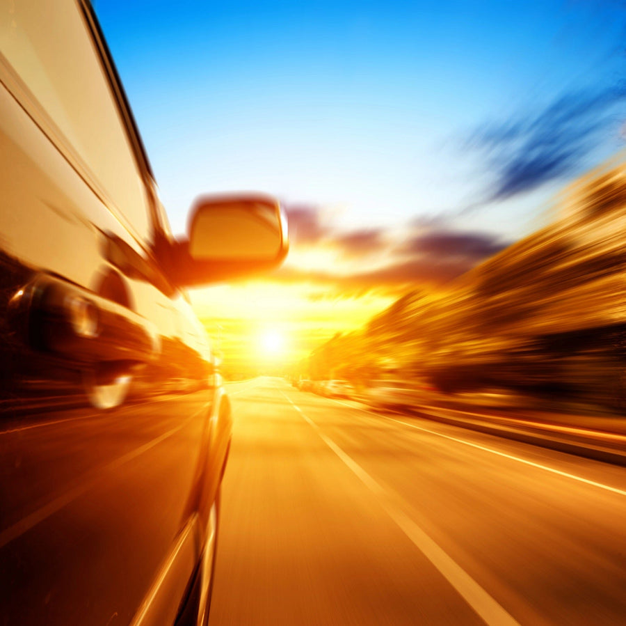 A modern bedroom with a computer desk, office chair, and single bed. Next to the bed is a High-Speed Car at Night Wall Mural, highlighted by two framed art prints and a sleek white wardrobe.