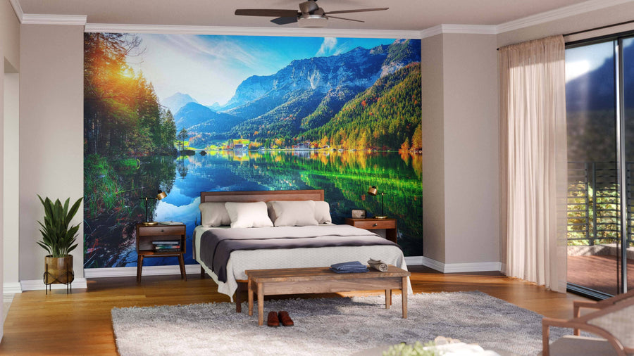 Modern living-dining room with wooden floors, teal armchairs, and a large Lake Hintersee and Reiter-Alm Wall Mural. Features a round dining table with chairs, pendant lights above, and an open kitchen visible in the background.