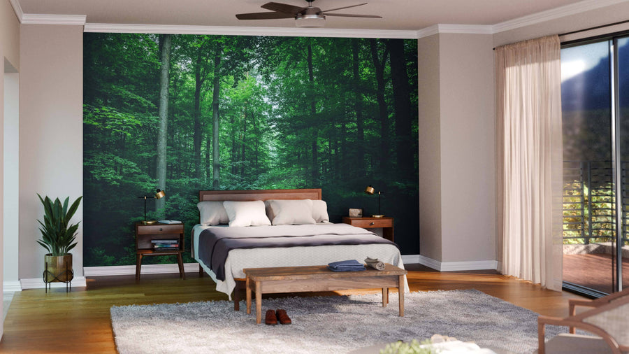 A modern living and dining space features wooden furniture, a patterned rug, and a Leafy Trees in the Forest Wall Mural. Pendant lights hang above a dark dining table, with an open layout leading to the kitchen in the background.