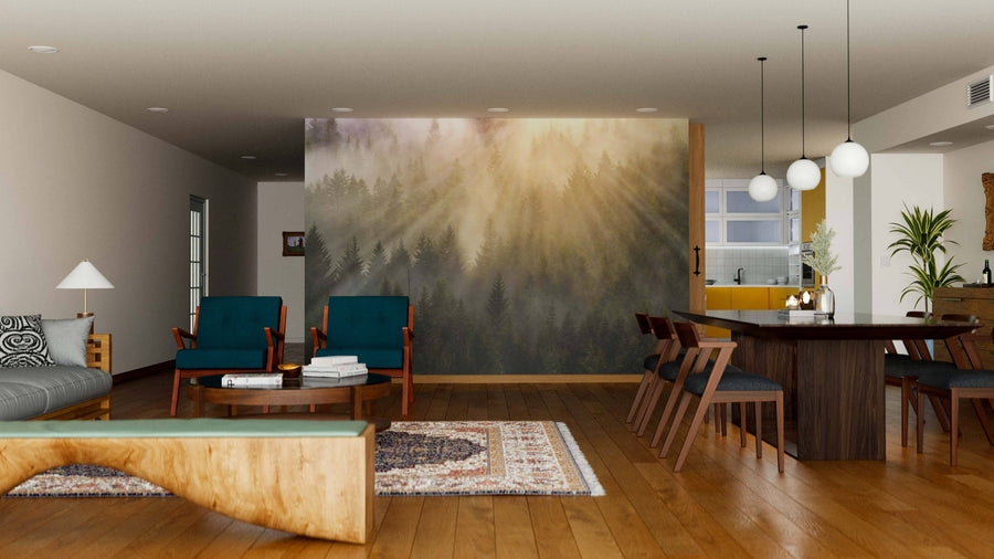 Modern open living-dining area with wood floors, green armchairs, gray sofa, and unique bench. The Foggy Forest with Sun Rays Wall Mural defines the space. Dining table, globe pendant lights, and kitchen are seen in the background.