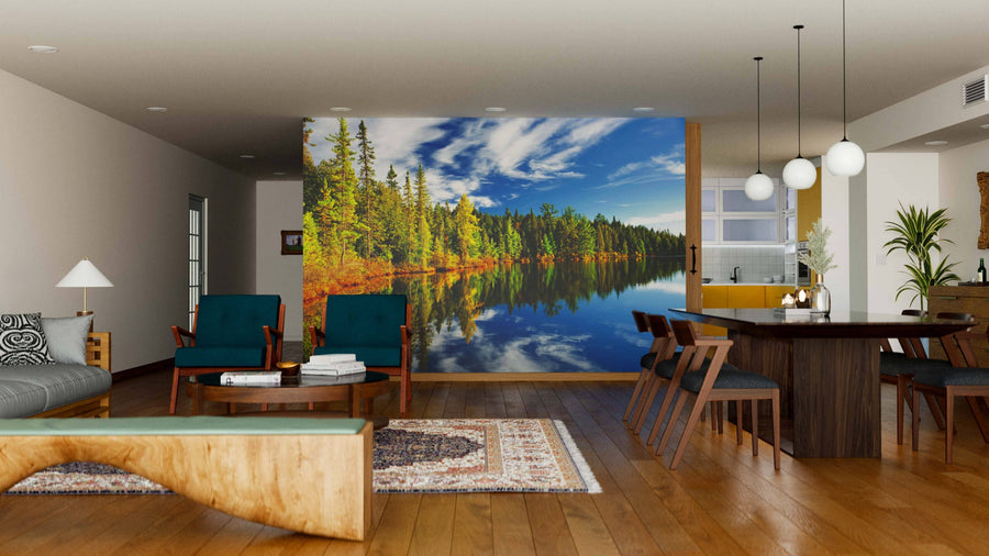 A stylish, cozy living-dining area with wooden floors, mid-century furniture, pendant lights, a rug, an open kitchen, and a Forest Reflecting in Lake Wall Mural as a scenic focal point.