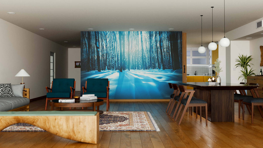 Modern living-dining space with wood floors, teal and brown furniture, rugs, and pendant lights. The Forest Trees Nature Snow Wood Wall Mural adds depth and a cool vibe to the warm-toned room with its snowy forest and blue sunlight design.