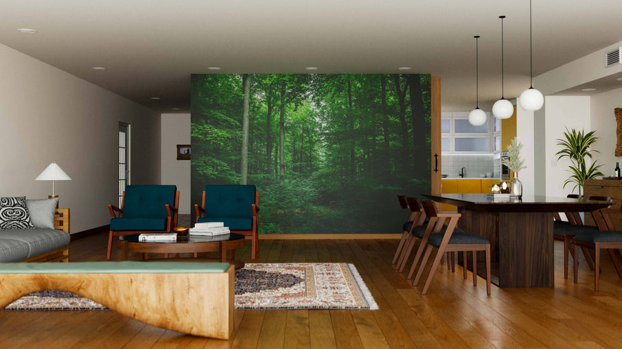 A modern living and dining space features wooden furniture, a patterned rug, and a Leafy Trees in the Forest Wall Mural. Pendant lights hang above a dark dining table, with an open layout leading to the kitchen in the background.