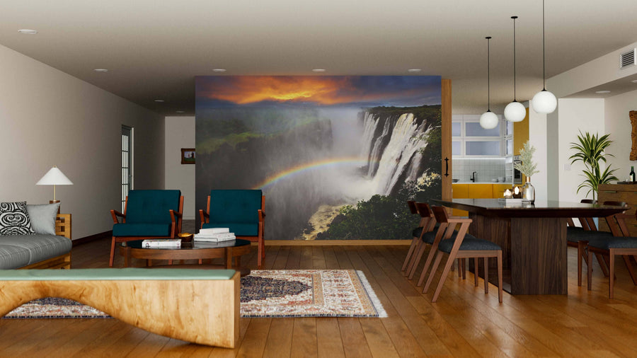 A modern open-plan living and dining room with wooden floors and mid-century furniture features the Rainbow at Waterfalls Wall Mural, adding a vivid waterfall with a rainbow as a striking focal point to the sleek, contemporary decor.
