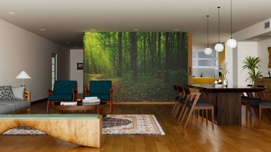 A modern open-plan living and dining room features wooden floors, stylish furniture, and a Trees in a Sunlit Green Forest Wall Mural. Pendant lights above a dark dining table create an airy, cozy, and nature-inspired atmosphere.