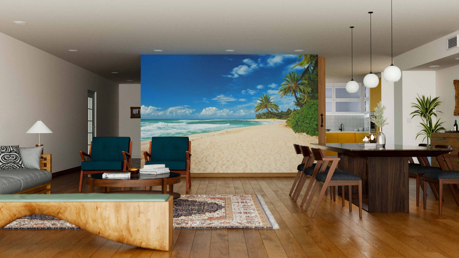 A modern living-dining room features wooden floors, stylish furniture, and the Untouched Sandy Beach Wall Mural with palm trees, blue sky, and ocean waves, adding a vibrant, relaxing touch to the neutral-toned space.