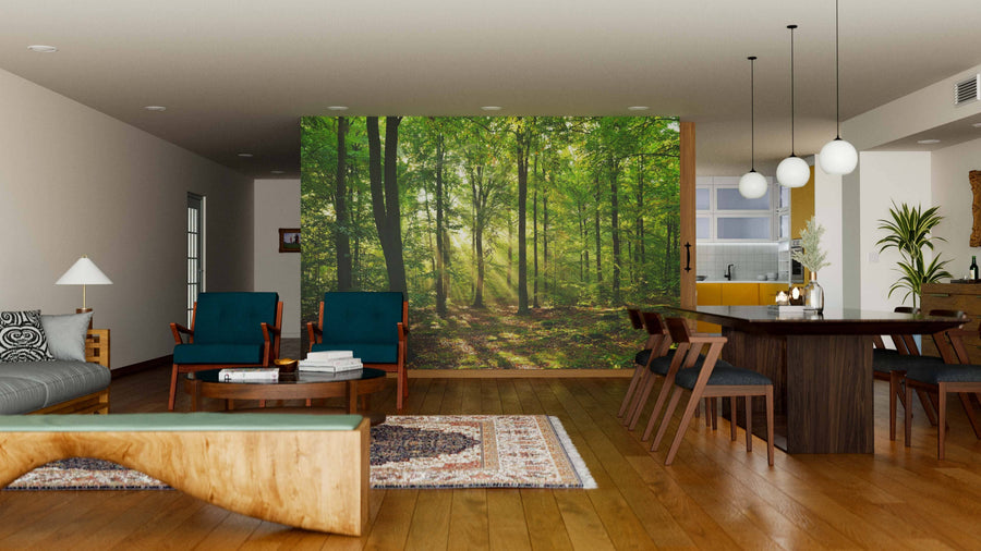 A modern living-dining room features wood flooring, mid-century furniture, a Wisconsin Green Forest Wall Mural on one wall, and globe pendant lights above a dark dining table. Natural light fills this cozy, nature-inspired space.