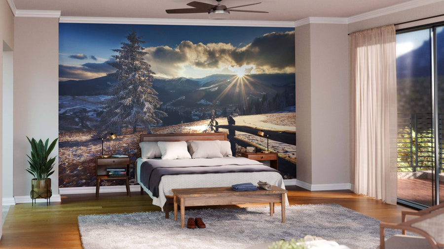 Modern open living-dining area with wooden floors, green chairs, a rug, round lamps above a dark wood dining table, and the Majestic Winter Landscape Glowing Wall Mural of a sunrise over snowy hills and trees. Kitchen visible in background.