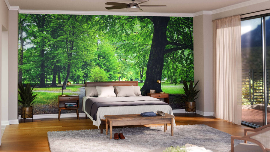 A modern living-dining room with wooden floors, teal chairs, and a sofa features the Park in Autumn Time Wall Mural, bringing nature indoors. Globular pendant lights add elegance above the spacious dining table.