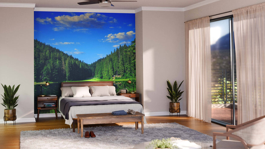 A modern living-dining room with wooden floors, green and wood furniture, rugs, pendant lights, and a striking large Pine Forest and Lake Wall Mural that brings a bright outdoors feel to the stylish interior.