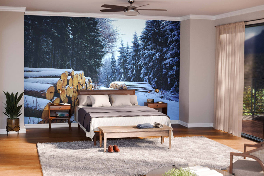 A modern living-dining space with wooden floors, blue armchairs, a wooden table, and the Pine Logs Under Snow Wall Mural. Soft lighting, a patterned rug, and minimalist furniture create a cozy, natural ambiance.