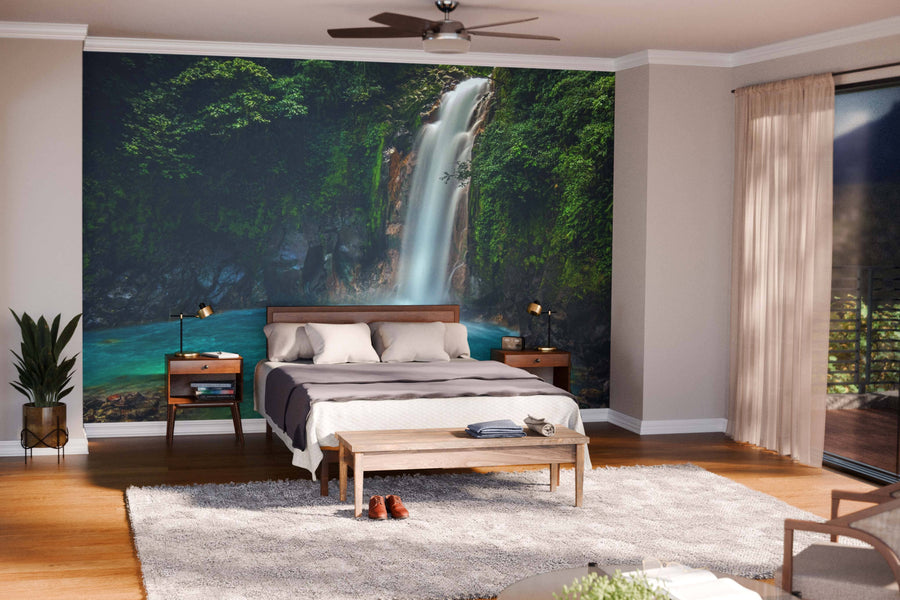 Modern open-plan living and dining area with wooden floors, mid-century furniture, and a Rio Celeste Waterfall Wall Mural. Pendant lights over the dining table and natural light create a cozy, inviting vibe.