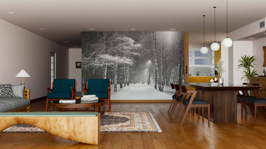 A modern living-dining room with wooden floors, teal and wood furniture, and pendant lights features the Snowstorm in a Birch Tree Park Wall Mural as a striking visual focal point on the back wall.