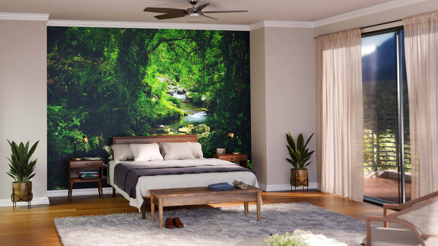 A modern living-dining room with wooden floors, teal armchairs, and a dining set features the Stream in Green Forest Wall Mural on the back wall, creating a stunning nature-inspired focal point for the space.