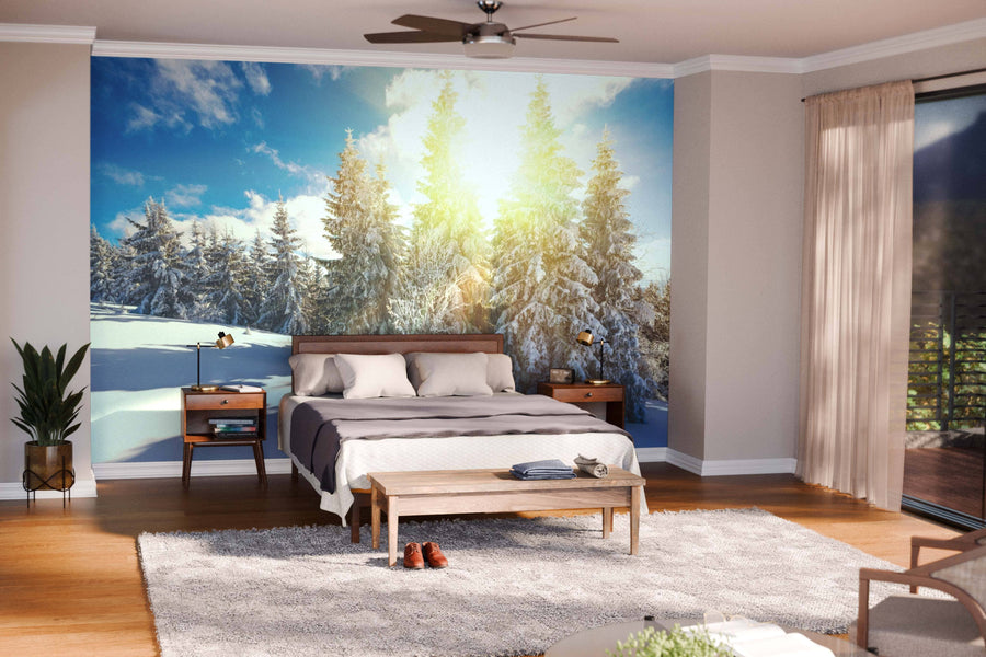 A cozy, modern living-dining room with wood floors and blue-toned furniture features the Stunning and Picturesque Winter Landscape Wall Mural, while spherical pendant lights above a dark dining table bring warmth to the inviting space.