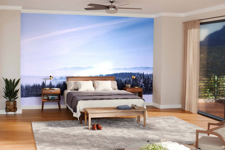 Modern open living-dining area with wood floors, mid-century furniture, and hanging lights. A large Sunshine and Winter Snowy Mountain Wall Mural is a focal point. Area rugs, wooden table, and teal chairs enhance the cozy, stylish space.