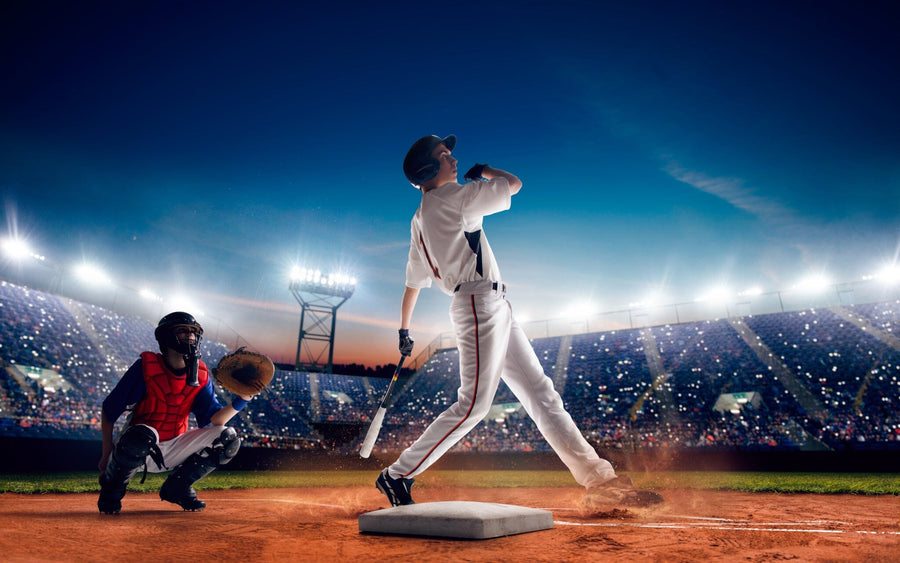 A modern bedroom showcases the Swing for the Fences Wall Mural, depicting a baseball player swinging in a bright stadium. The room has a desk, chair, daybed, and sports balls on the floor, with sunlight streaming through white shutters.