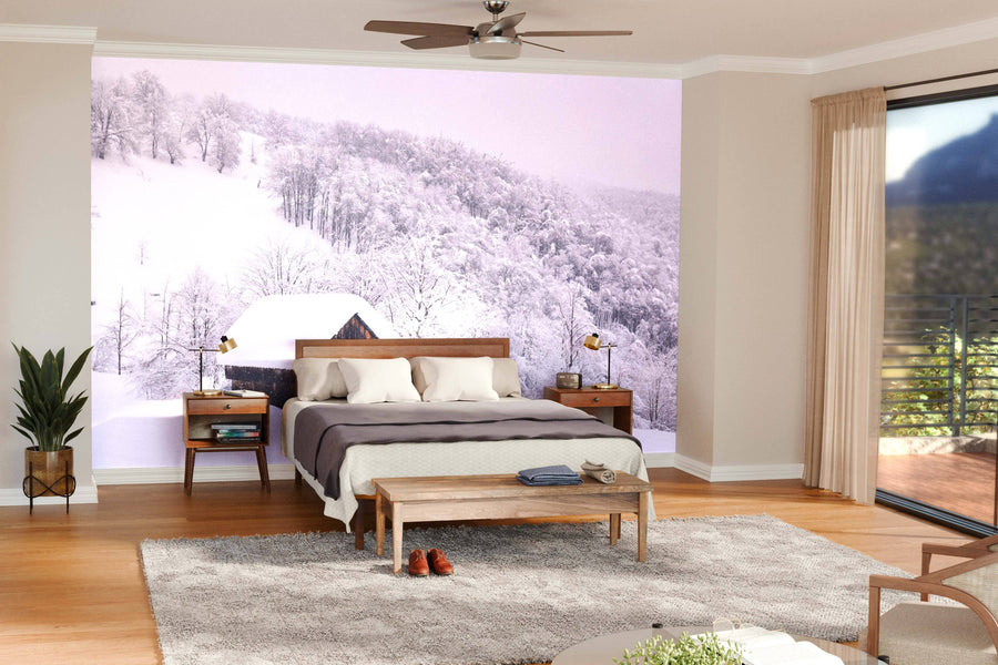 A modern, open living-dining space features wood floors, teal armchairs, a gray sofa, a wooden dining table under pendant lights, and a Winter Landscape with Wooden House Wall Mural that adds striking visual interest to one wall.