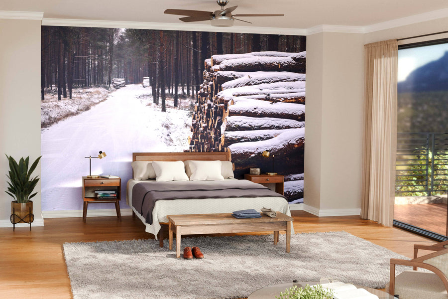 Modern open-plan living and dining space with wood floors, teal chairs, and a dark table. The Wooden Prisms Covered with Snow Wall Mural displays a snowy forest path and logs, bringing wintry outdoor charm indoors.