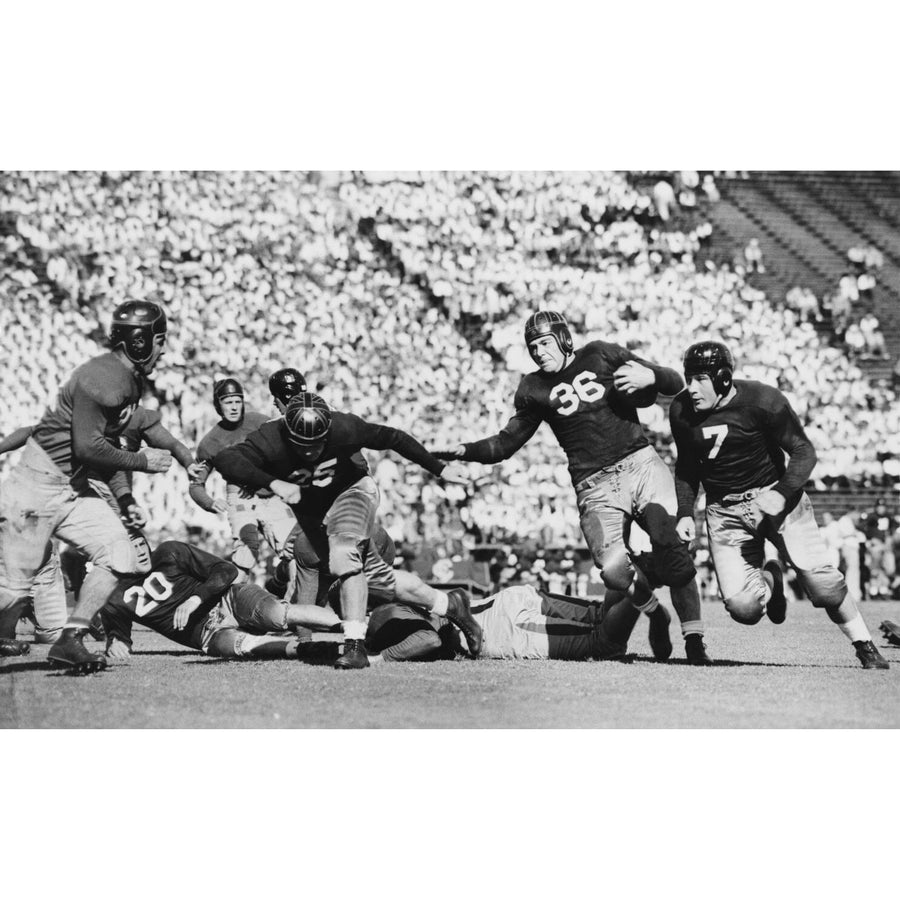 A modern bedroom with a desk, chair, and daybed features the Touchdown Wall Mural—a large black-and-white custom mural of a vintage football game. Sunlight filters through window blinds, casting dramatic shadows across the floor.