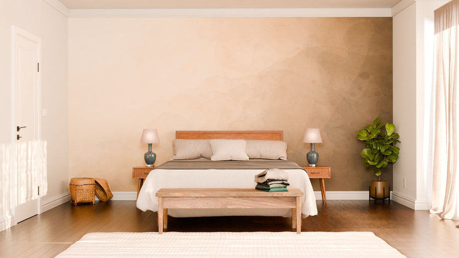 A minimalist bedroom reveals a wooden bed adorned with beige and gray bedding. Two bedside tables hold matching gray lamps. A bench with folded clothes rests at the foot of the bed, while a potted plant stands nearby. Soft light cascades through sheer curtains onto the "A Way Out" wall mural on the right wall.