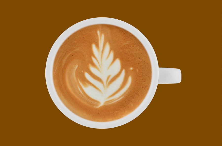 A modern café interior with wooden tables, stools, pendant lights, and large windows features the Art in Coffee Wall Mural—a giant print of a coffee cup with latte art. Small plants on each table add a fresh touch.
