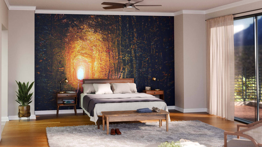 A modern bedroom is styled with gray and white bedding, wood furniture, and a potted plant. Behind the bed, the Autumn Trees Tunnel Wall Mural acts as a warm focal point that’s easy to update thanks to its removable wallpaper design.