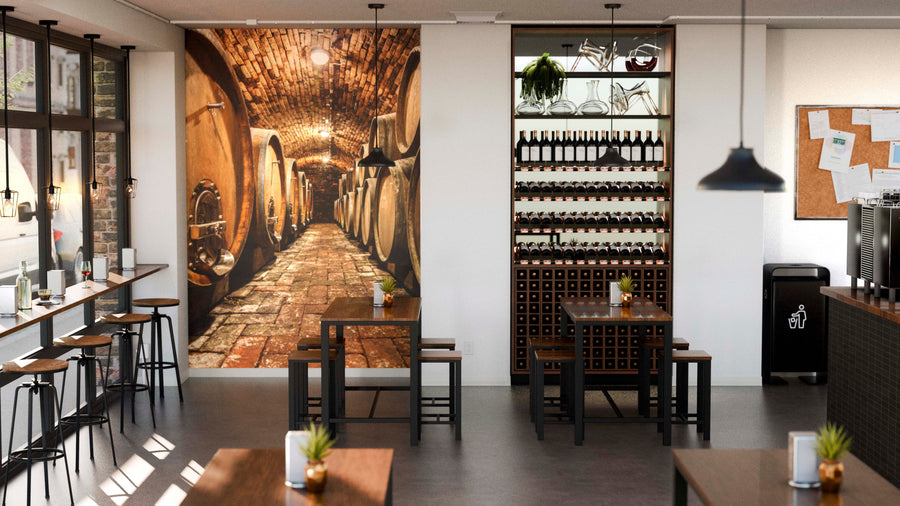 A modern wine bar interior features wooden tables and stools, shelves of wine bottles, hanging pendant lights, large windows for natural light, and a custom Large Wooden Barrels Wall Mural evoking an authentic wine cellar ambiance.
