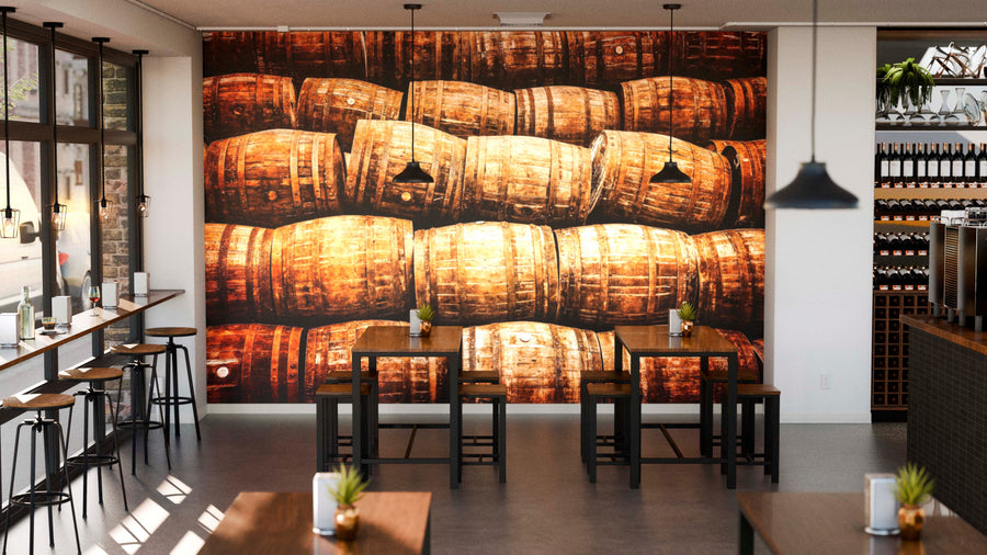 A modern café with wooden tables, black chairs, and potted plants. The main wall showcases the Old Vintage Wine Barrels Wall Mural, creating a warm, rustic vibe. Pendant lights hang above, and plants decorate tables and window ledges.