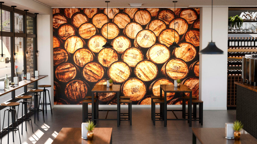A modern café with wooden tables, bar seating by large windows, and a vibrant Whisky and Wine Wooden Barrels Wall Mural. Pendant lights and small potted plants bring warmth to the clean, industrial interior.