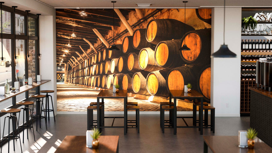 A modern café with wooden tables, barstools by large windows, and the Wine Cellar in Porto Wall Mural as a striking feature creates a cozy vibe. Small potted plants accent the tables for added warmth.