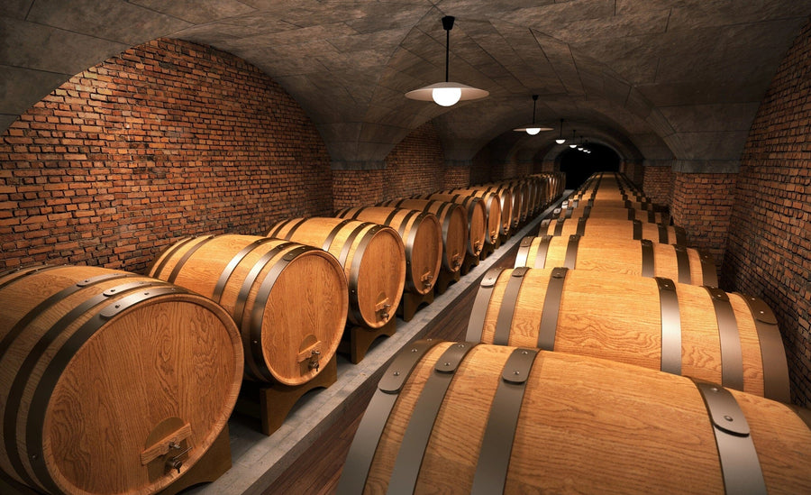A modern cafe with wooden tables and high stools features the "Barrels in Cellar Wall Mural," exposed brick walls, pendant lights, and small plants on tables, creating a cozy atmosphere.