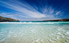 Sandy beach with waves and blue water at a Beautiful Bay – Peel and Stick Wall Murals
